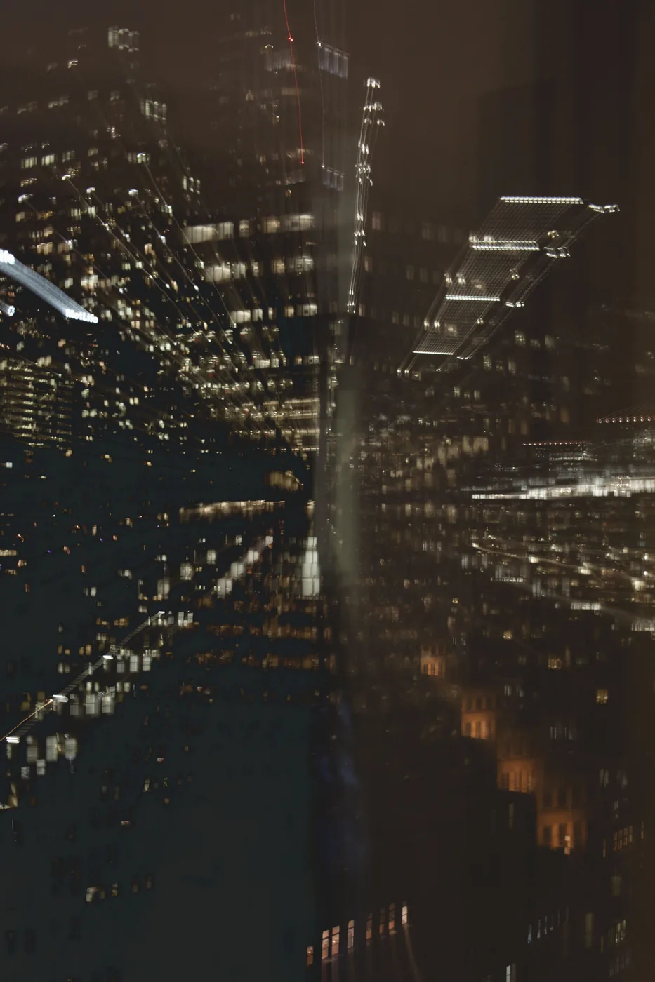 City towers at night smeared into layered trails of light by a long exposure.