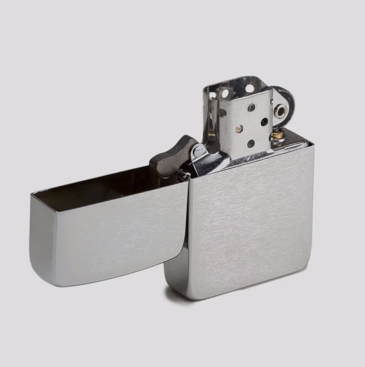A 1941 Zippo lighter replica in brushed steel, lid open to show the perforated chimney and flint wheel.